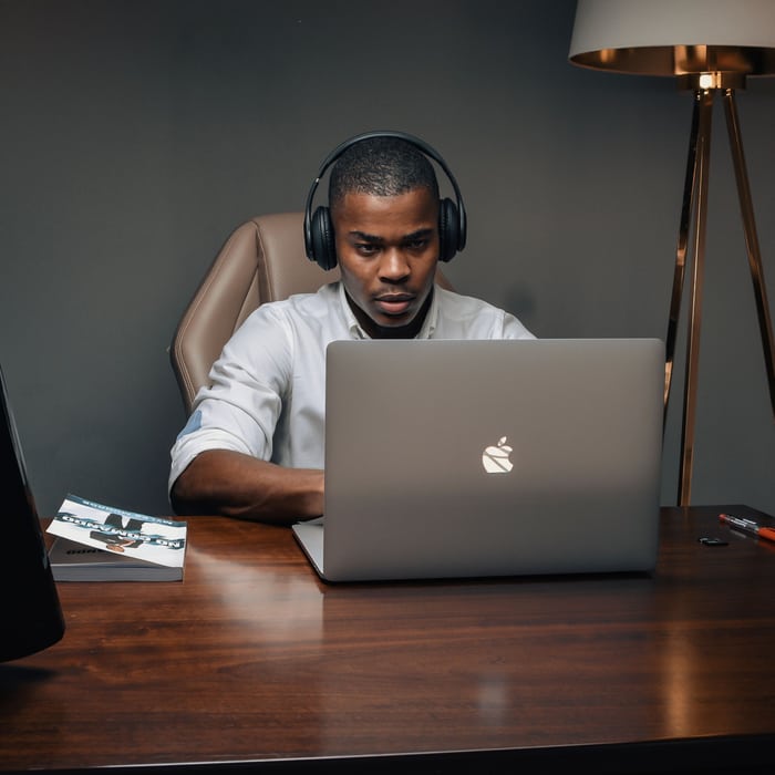 Designer at his desk building a site on a laptop